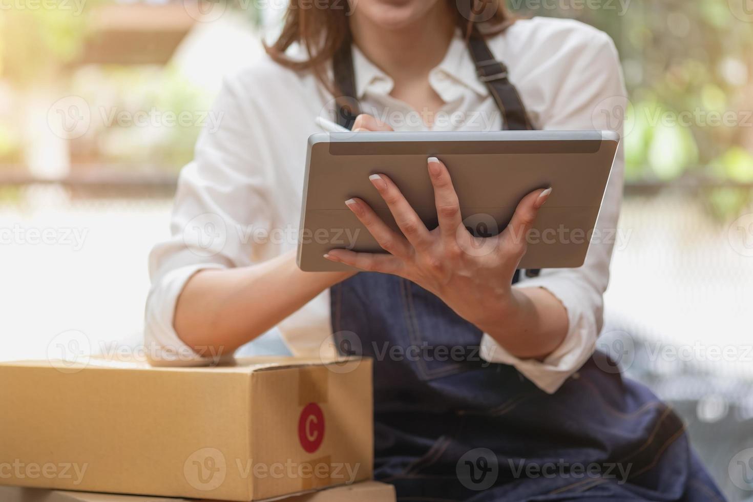 Young businesswoman using a tablet to check online product sales photo