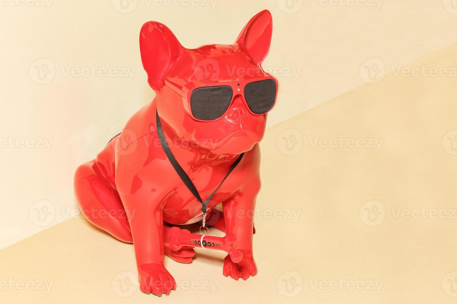 A cool figurine of a red guard dog with black glasses and a hidden surveillance camera on his forehead. photo