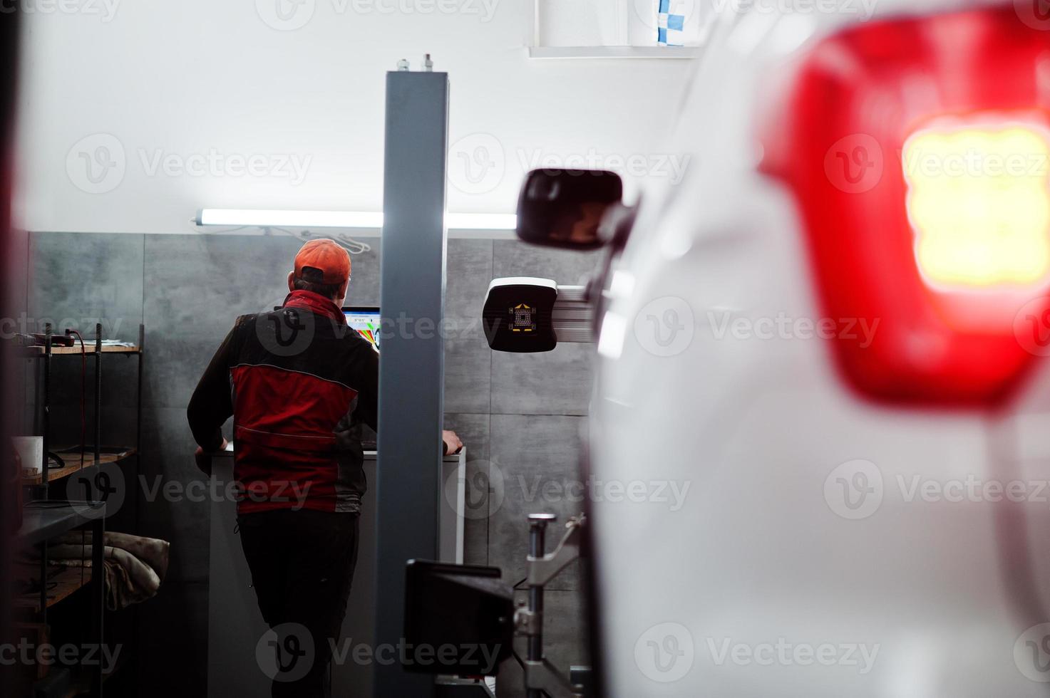 Auto mechanic sets american SUV car for diagnostics and configuration camber check in workshop of service station.. photo