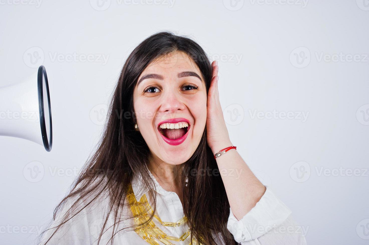 Close-up portrait of a woman covering her ears because of the megaphone. photo