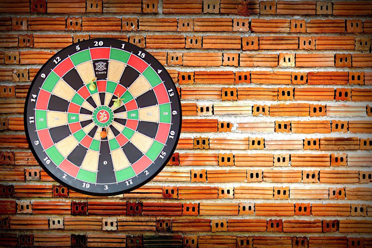 Dartboard on brick wall photo