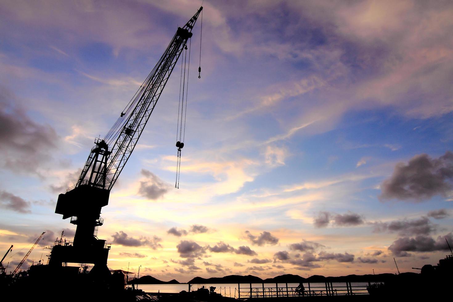 grúas en el muelle al atardecer foto