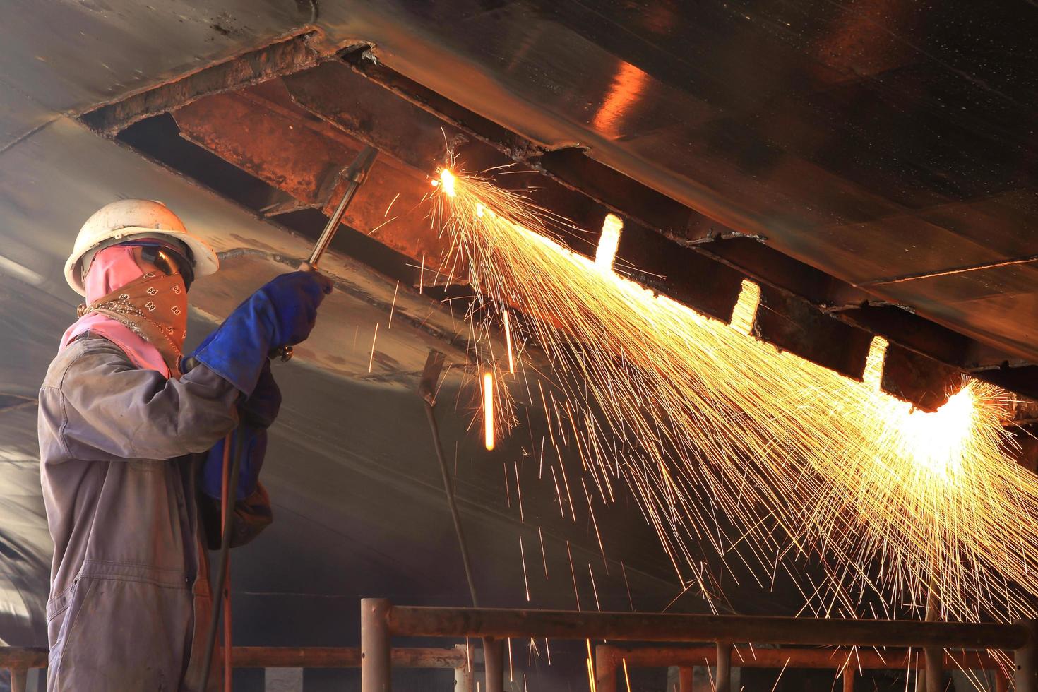 a welder working a torch at shipyard photo