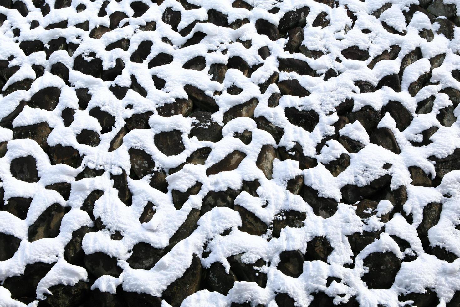 muro de piedra cubierto de nieve i foto