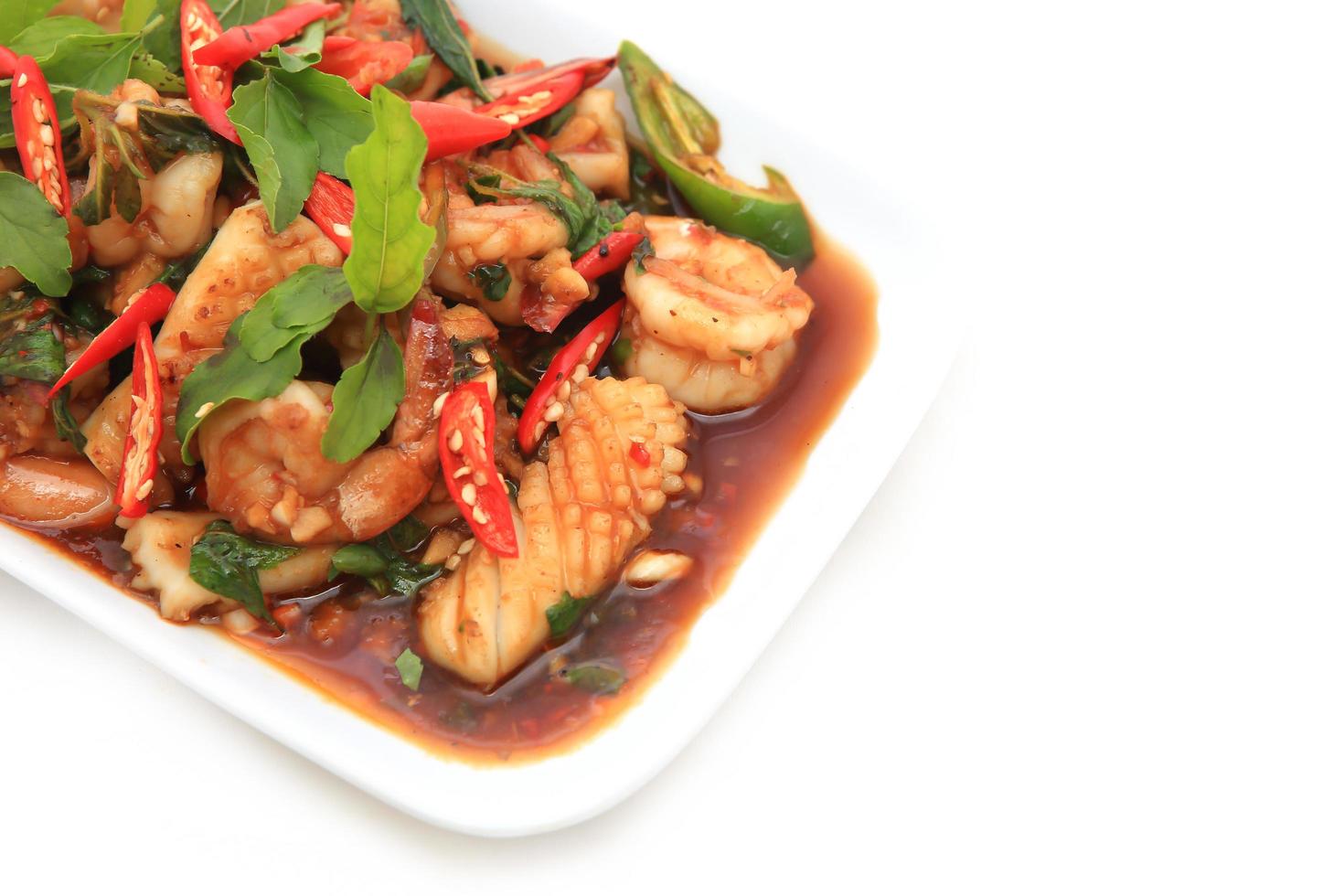Spicy seafood fried served on white dish photo