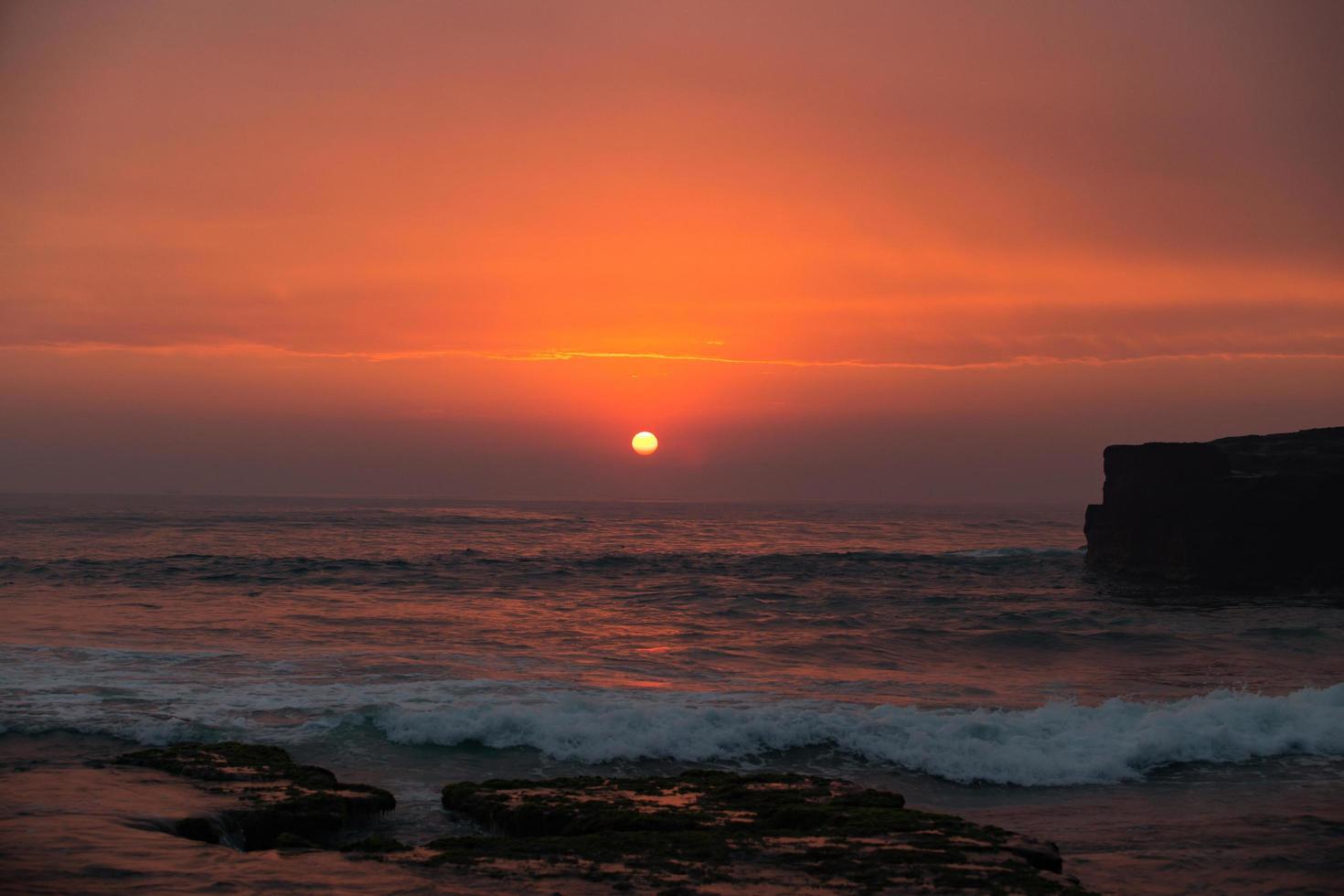 sunset over hindu temple Pura Tanah Lot, Bali, Indonesia photo