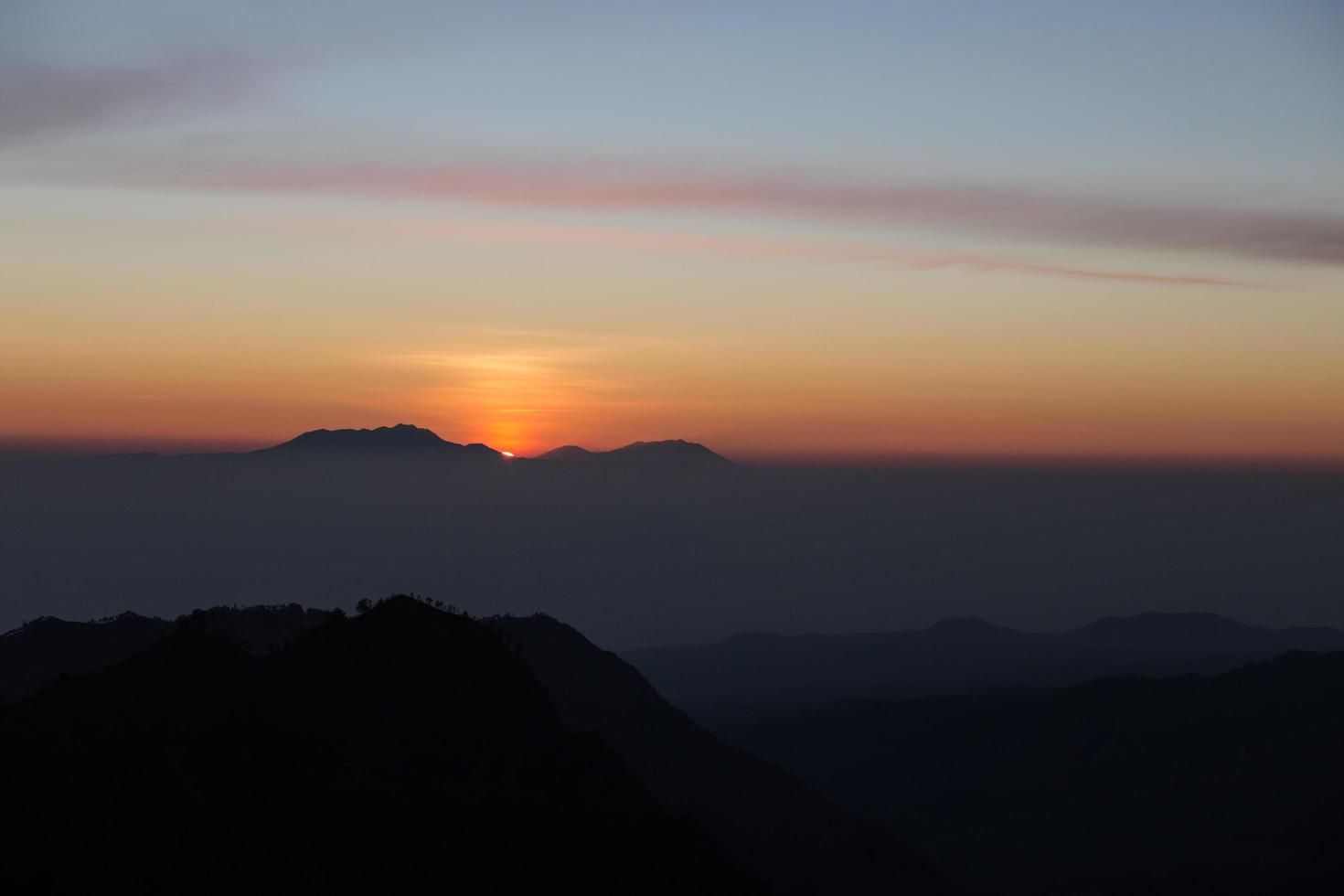 Foggy and volcano mountain during sunrise taken from Pinajagun II view point ,Indonesia photo