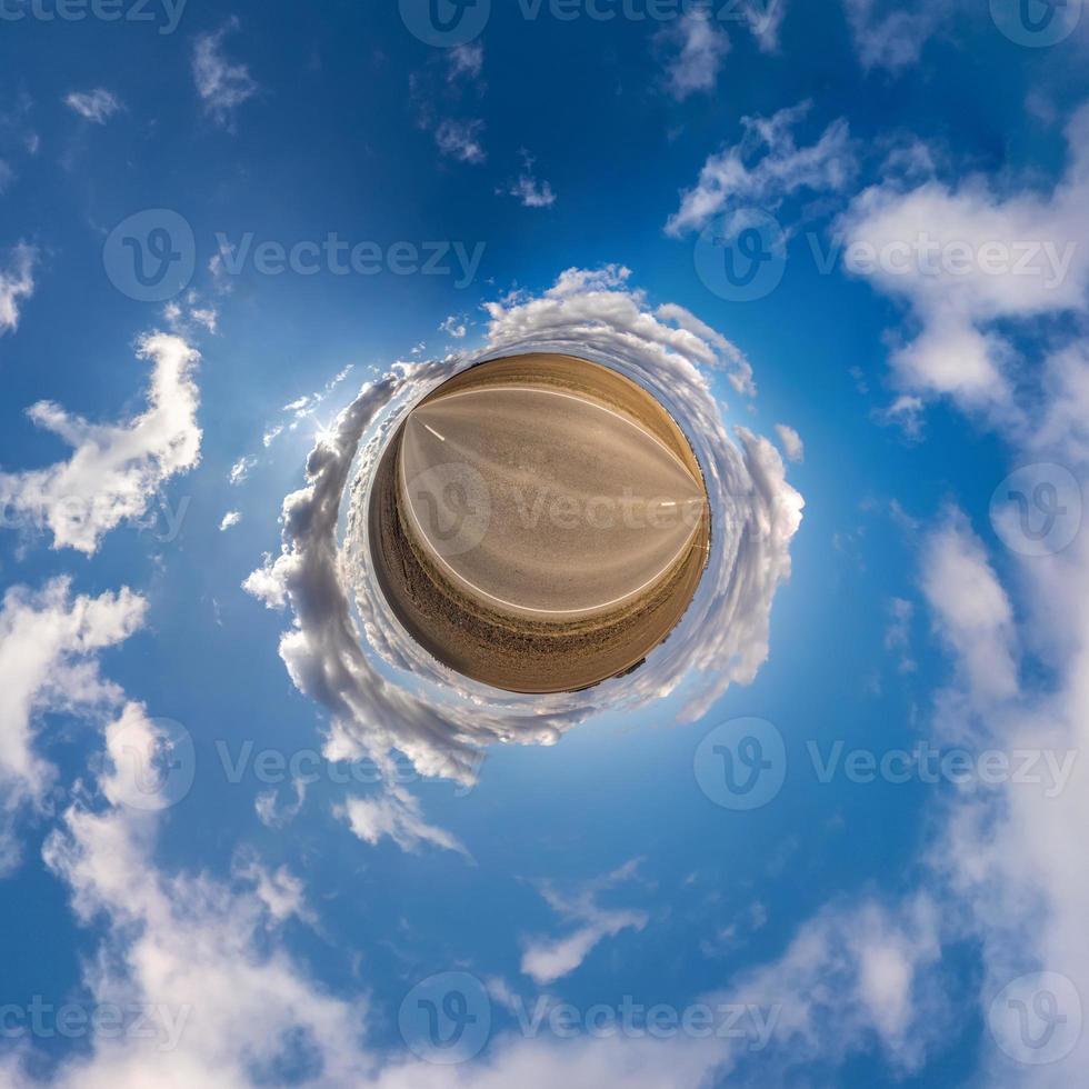 Little planet transformation of spherical panorama 360 degrees. Spherical abstract aerial view in field with awesome beautiful clouds. Curvature of space. photo