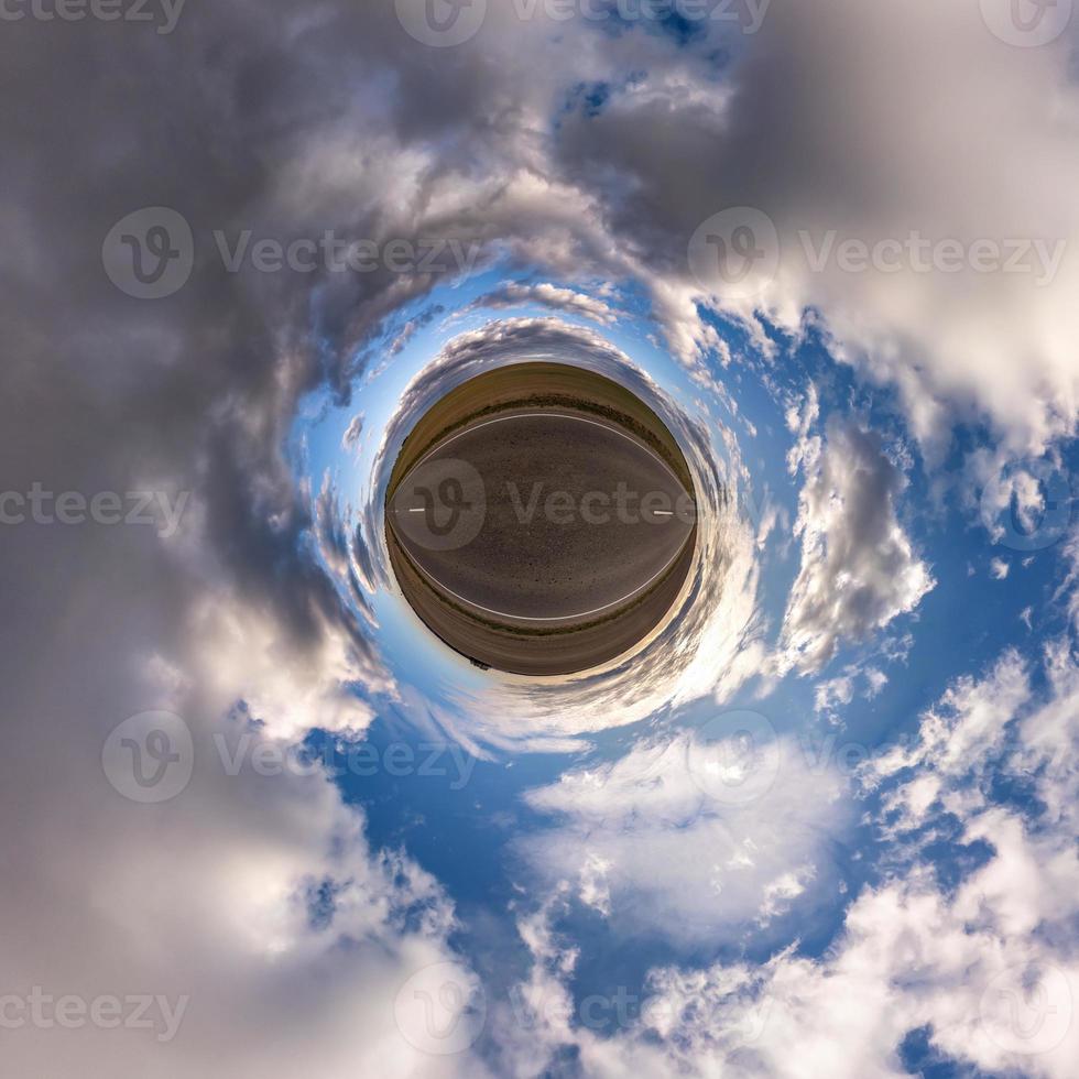 Little planet transformation of spherical panorama 360 degrees. Spherical abstract aerial view in field with awesome beautiful clouds. Curvature of space. photo