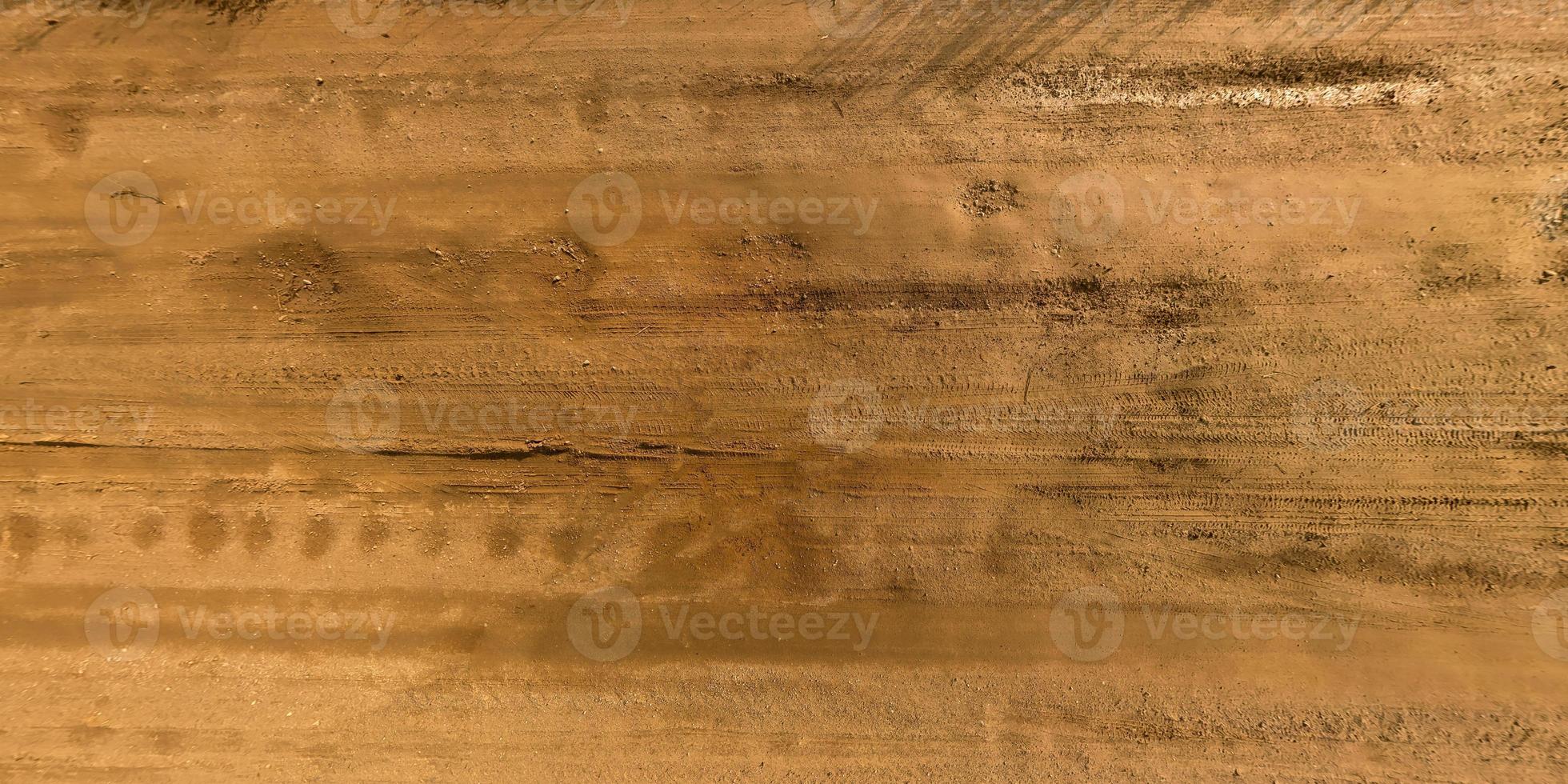 view from above on texture of gravel road with car tire tracks photo