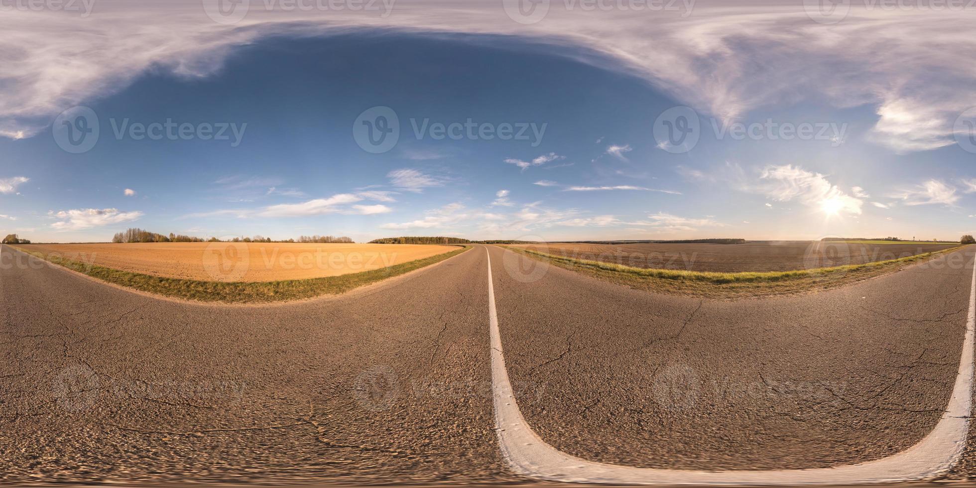 vista de ángulo de 360 grados de panorama hdri esférico completo sin tráfico en carretera asfaltada entre campos en el día de primavera con noche nublada en proyección equirectangular, contenido vr ar foto