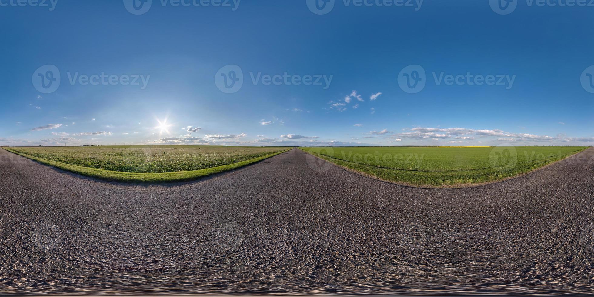 Full spherical seamless panorama 360 degrees angle view on old no traffic asphalt road among fields in evening  before sunset with clear sky in equirectangular projection, VR AR content photo