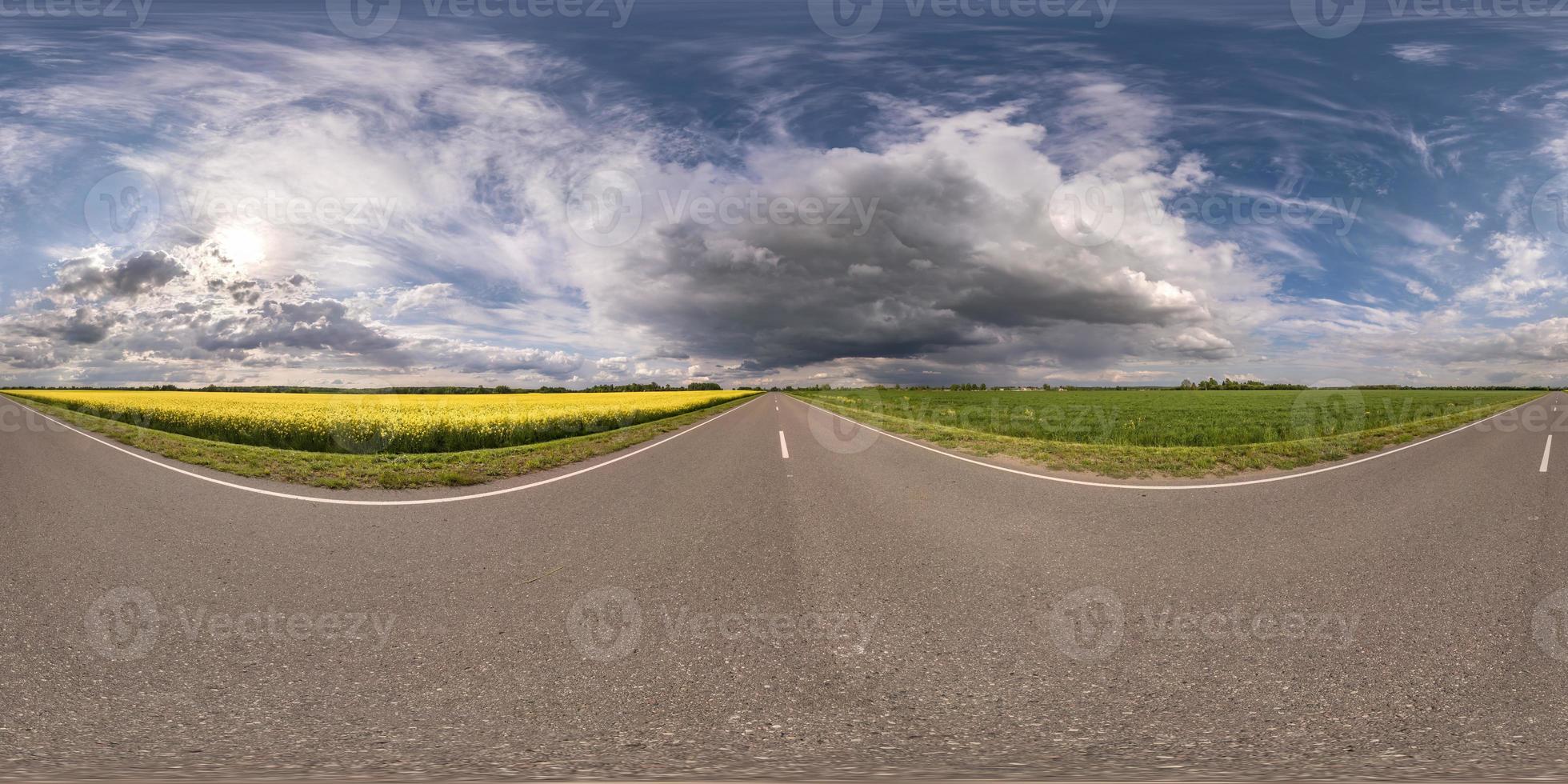 Full spherical seamless hdri panorama 360 degrees angle view on no traffic asphalt road among fields with cloudy sky in equirectangular projection, VR AR content photo