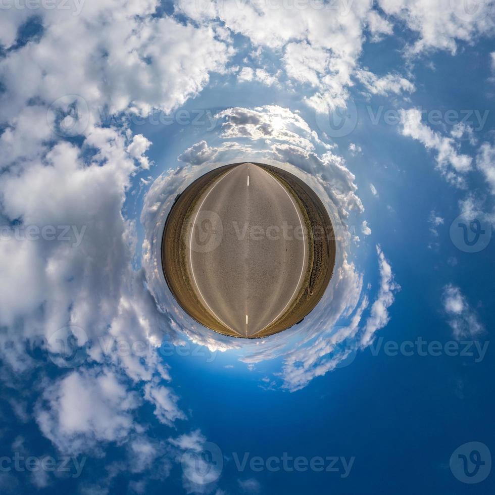 Little planet transformation of spherical panorama 360 degrees. Spherical abstract aerial view in field with awesome beautiful clouds. Curvature of space. photo