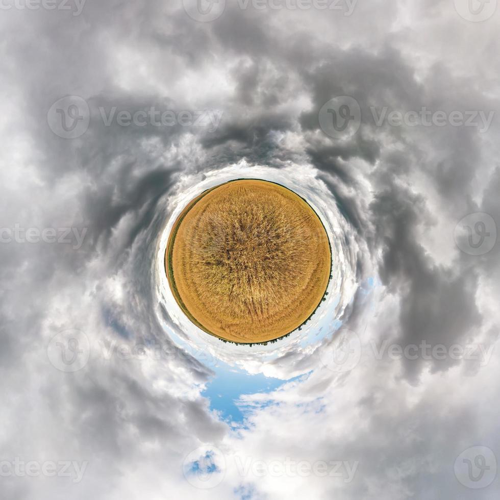 Little planet transformation of spherical panorama 360 degrees. Spherical abstract aerial view in field with awesome beautiful clouds. Curvature of space. photo