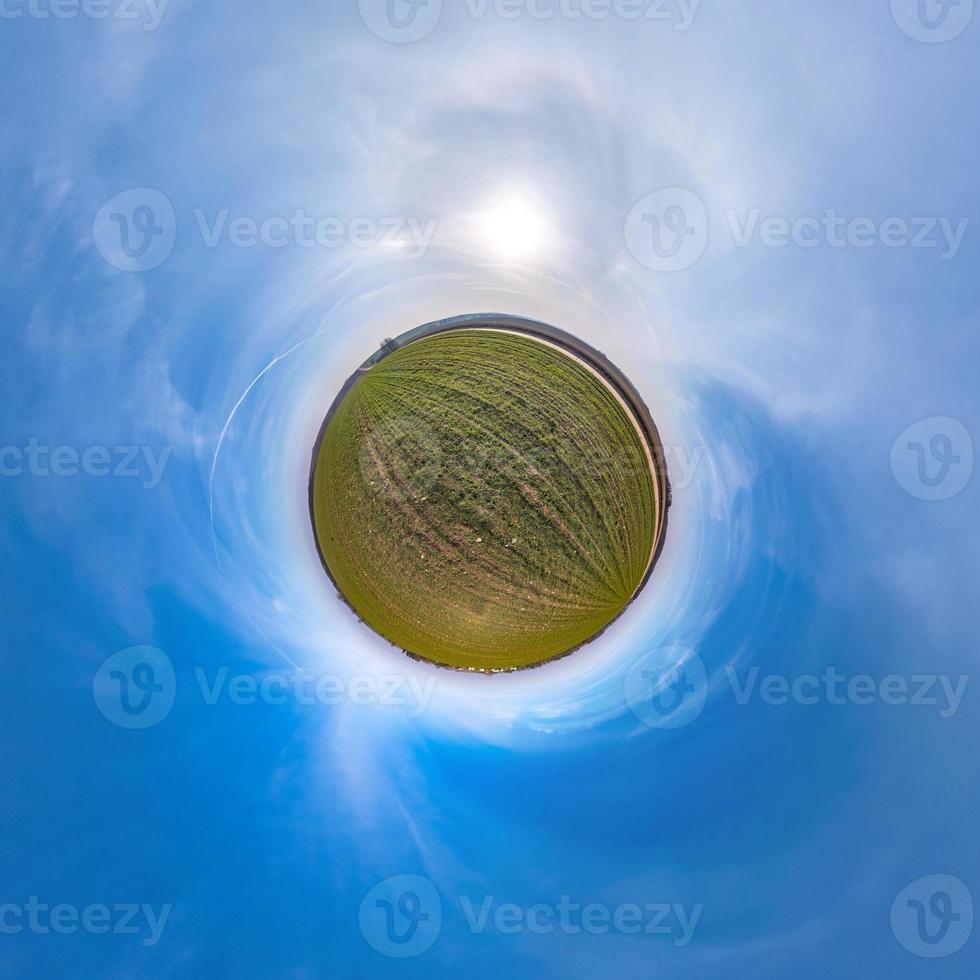 Little planet transformation of spherical panorama 360 degrees. Spherical abstract aerial view in field with awesome beautiful clouds. Curvature of space. photo