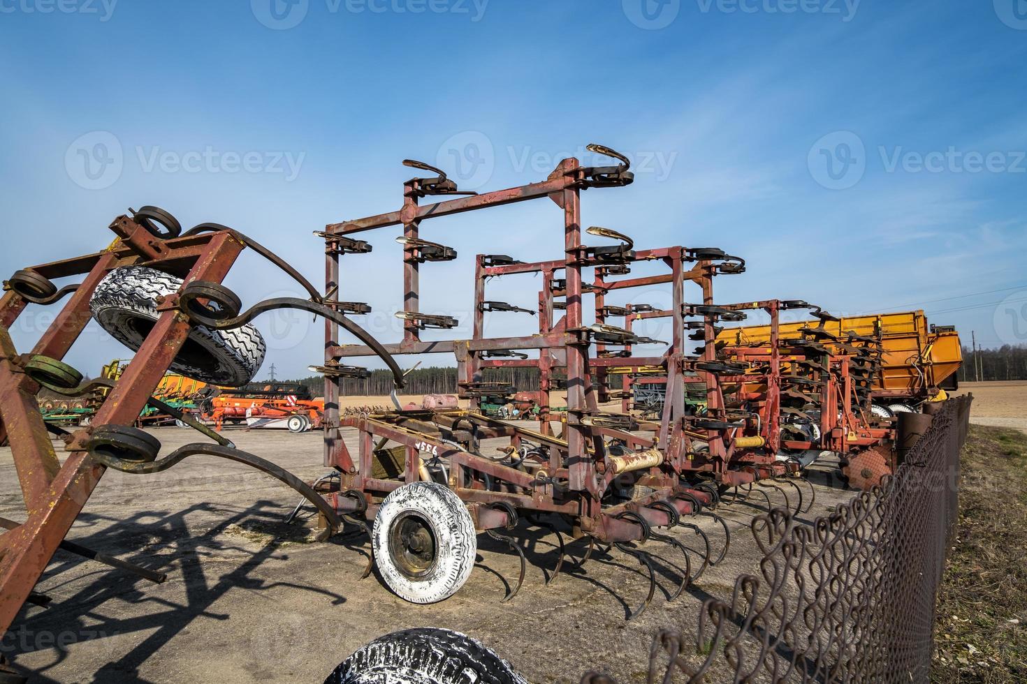 Parking agricultural machinery and harvest. rows of plows, cultivators, bodies photo