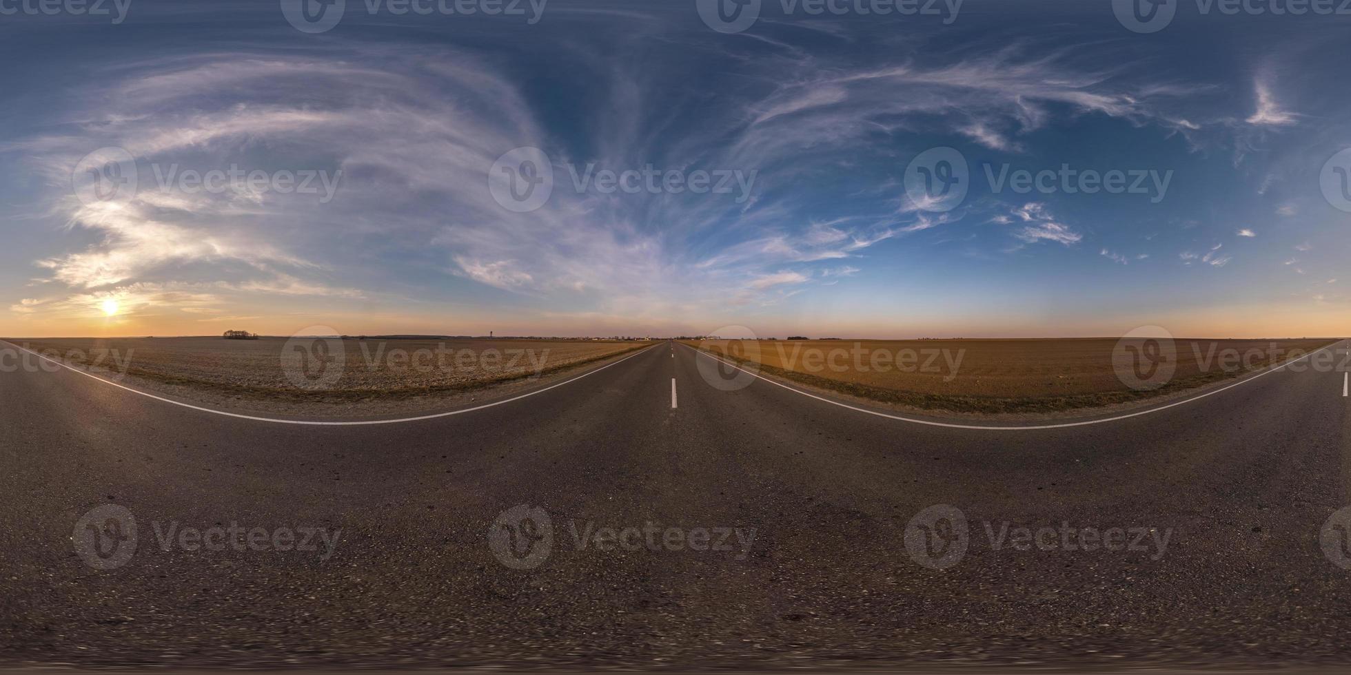 Full spherical seamless panorama 360 degrees angle view on no traffic asphalt road among fields in evening  before sunset with cloudy sky. 360 panorama in equirectangular projection, VR AR content photo