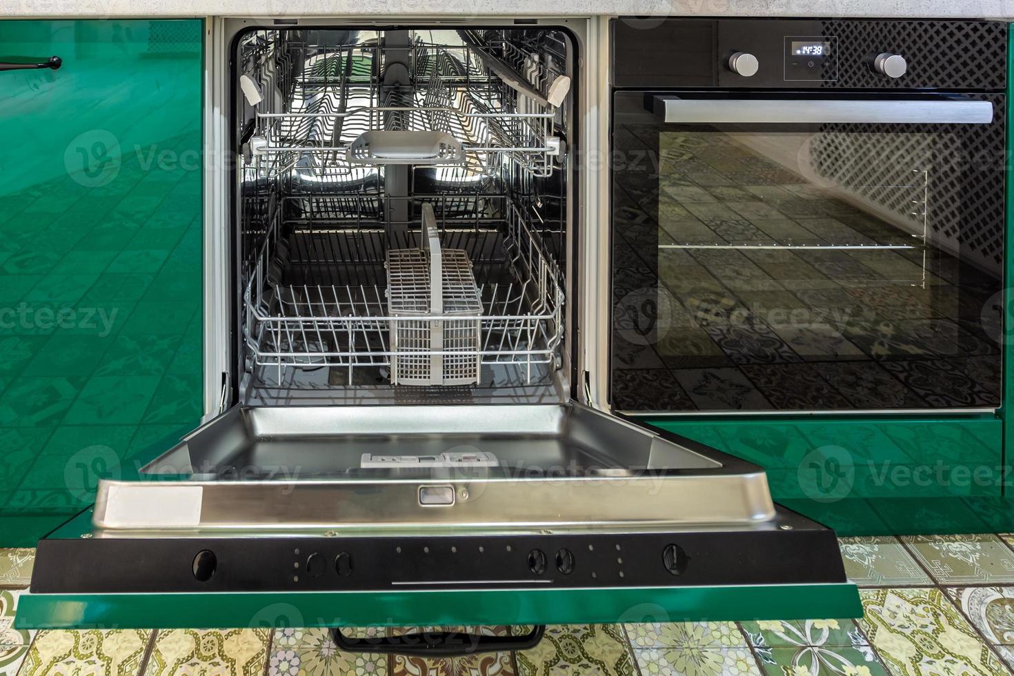 Interior of the modern kitchen with opened Dishwasher in loft flat apartment in minimalistic style with green color photo