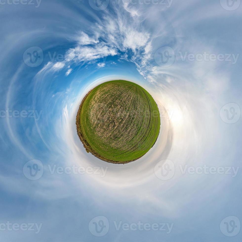 Little planet transformation of spherical panorama 360 degrees. Spherical abstract aerial view in field with awesome beautiful clouds. Curvature of space. photo