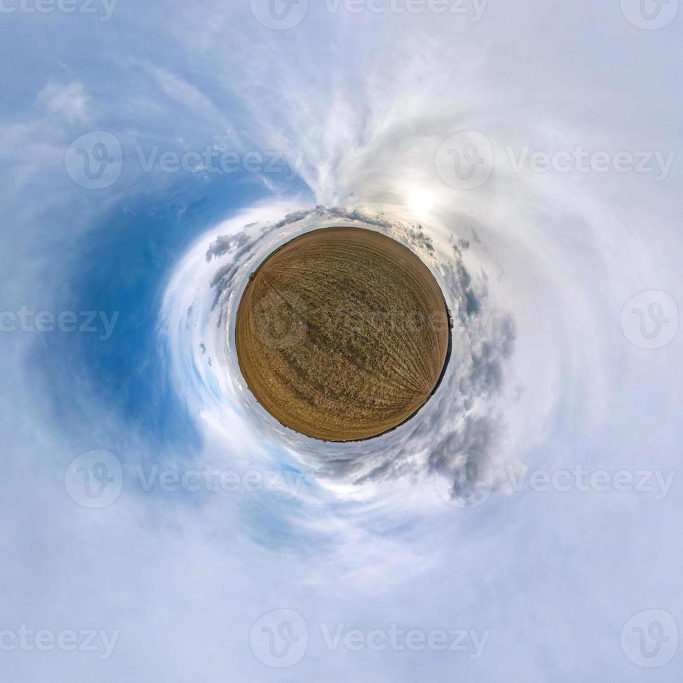 Little planet transformation of spherical panorama 360 degrees. Spherical abstract aerial view in field with awesome beautiful clouds. Curvature of space. photo