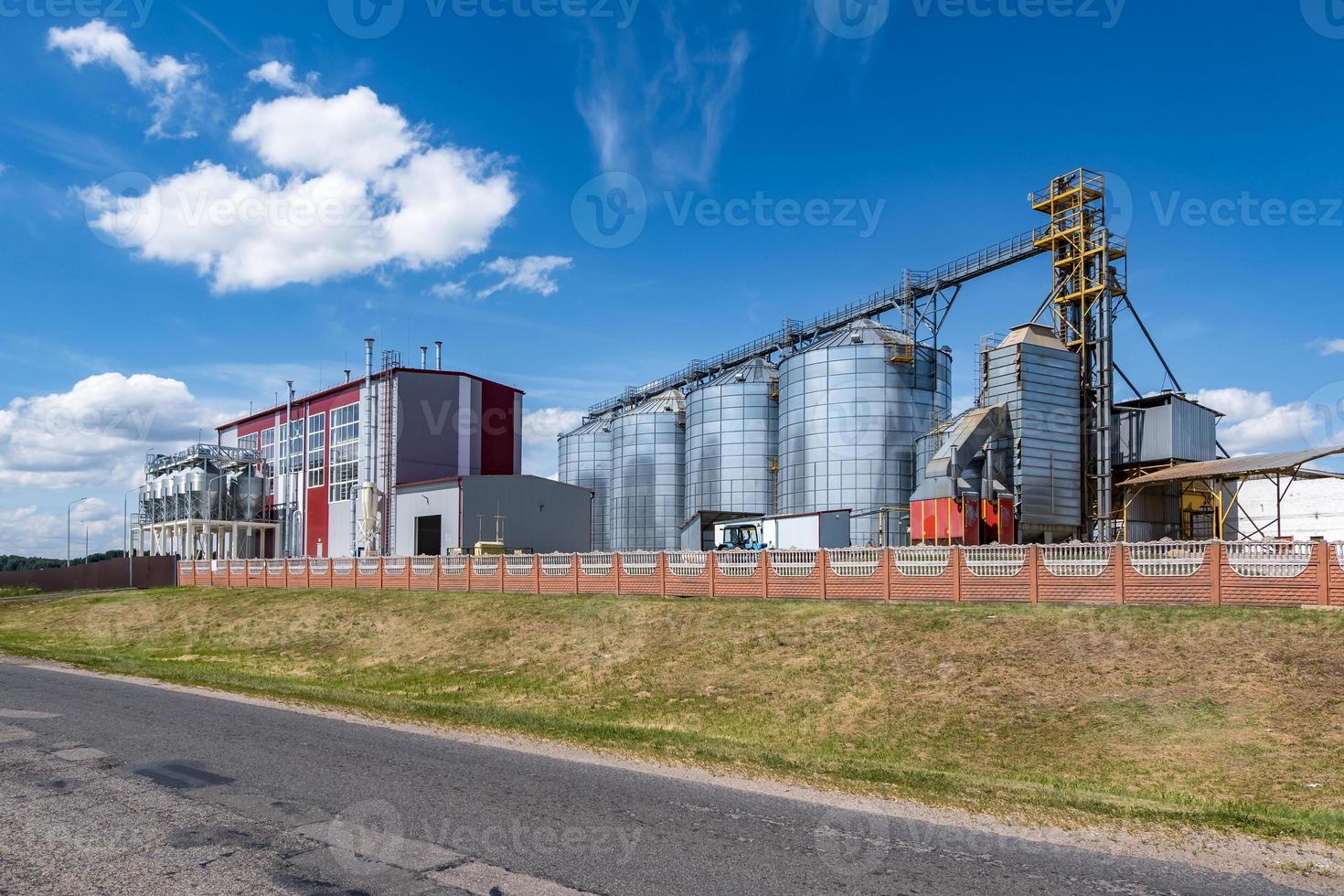 Modern Granary elevator. Silver silos on agro-processing and manufacturing plant for processing drying cleaning and storage of agricultural products, flour, cereals and grain. photo