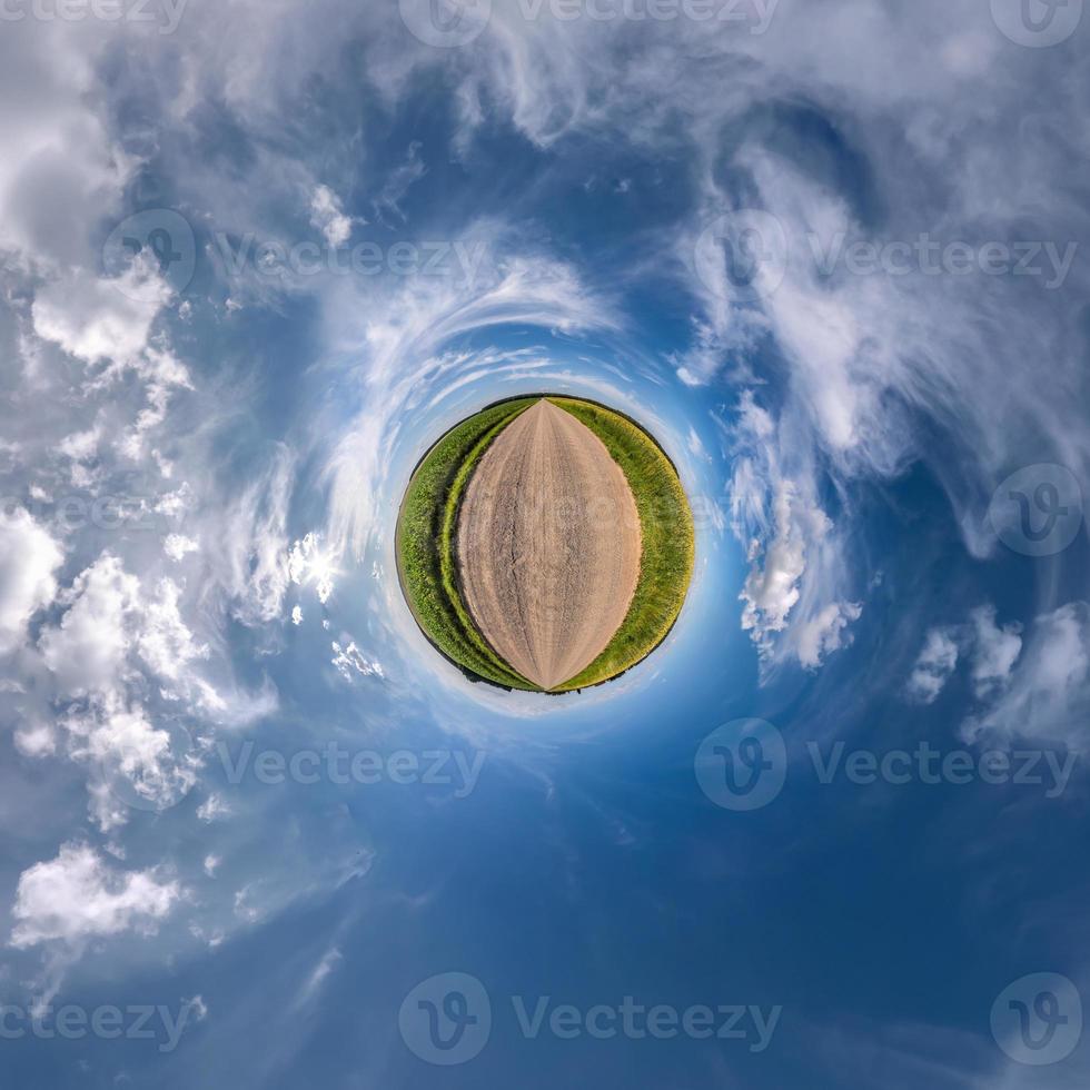 Little planet transformation of spherical panorama 360 degrees. Spherical abstract aerial view in field with awesome beautiful clouds. Curvature of space. photo