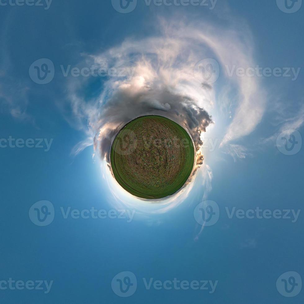 Little planet transformation of spherical panorama 360 degrees. Spherical abstract aerial view in field with awesome beautiful clouds. Curvature of space. photo