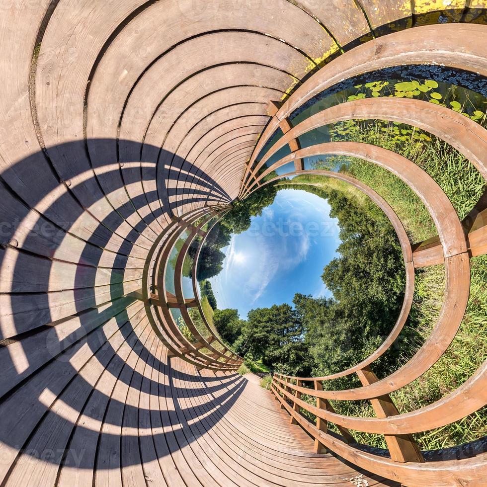 Little planet transformation of spherical panorama 360 degrees. Spherical abstract aerial view on wooden bridge. Curvature of space. photo