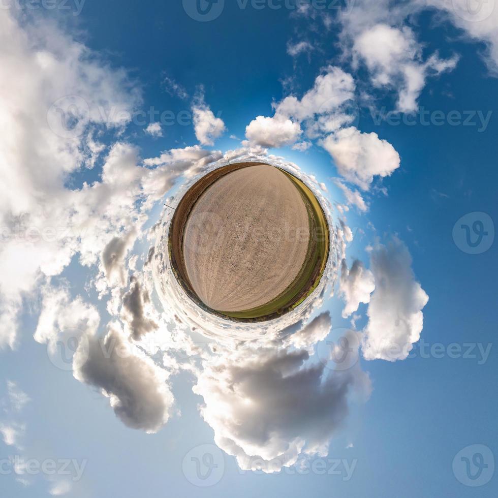 Little planet transformation of spherical panorama 360 degrees. Spherical abstract aerial view in field with awesome beautiful clouds. Curvature of space. photo