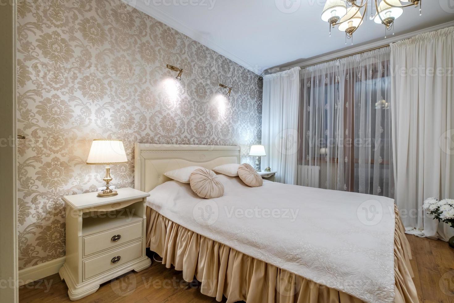 Interior of the modern luxure bedroom with pillows on the bed in studio apartments in light color style photo
