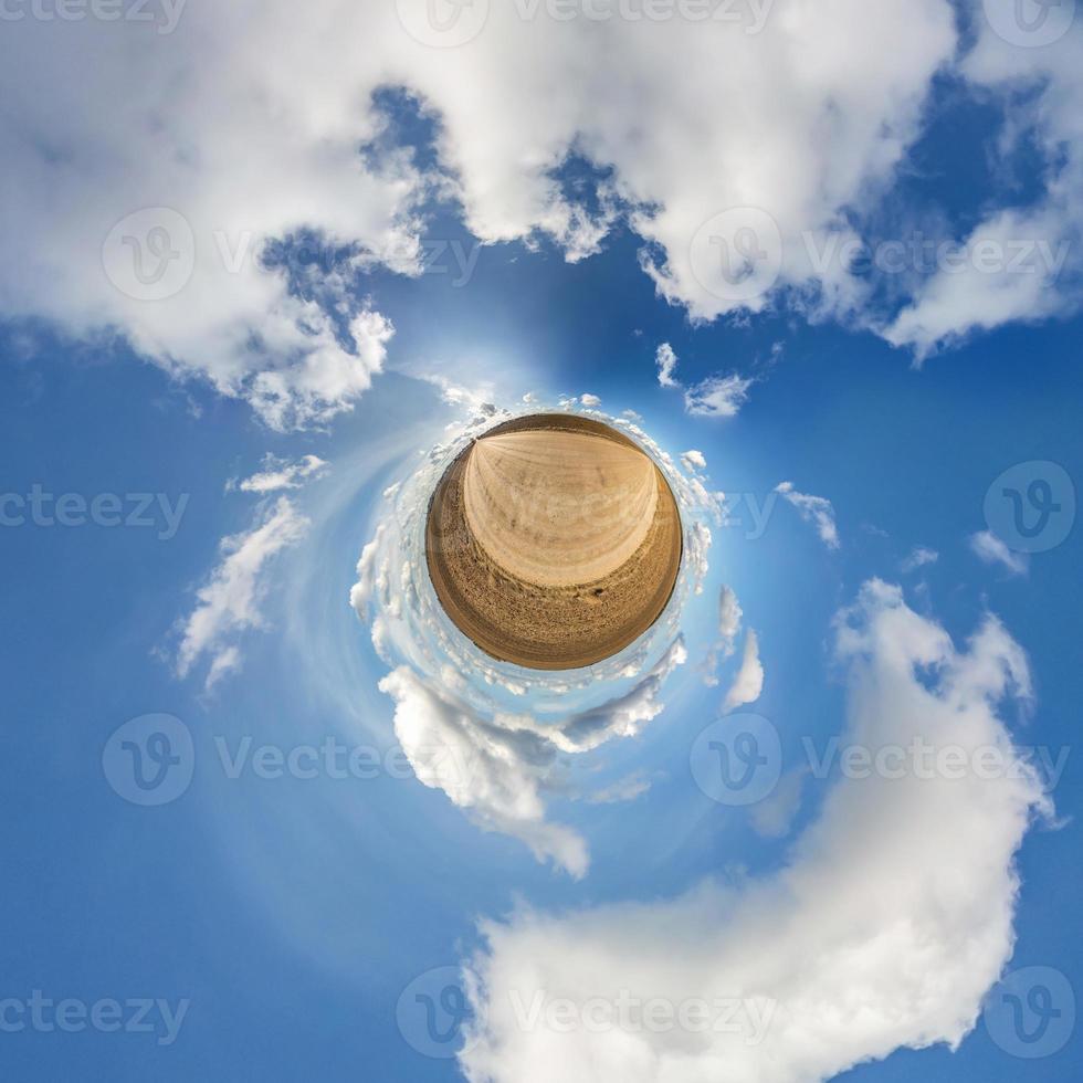 Little planet transformation of spherical panorama 360 degrees. Spherical abstract aerial view in field with awesome beautiful clouds. Curvature of space. photo