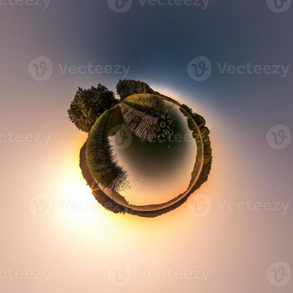 Little planet transformation of spherical panorama 360 degrees. Spherical abstract aerial view in field in nice evening with awesome beautiful clouds. Curvature of space. photo