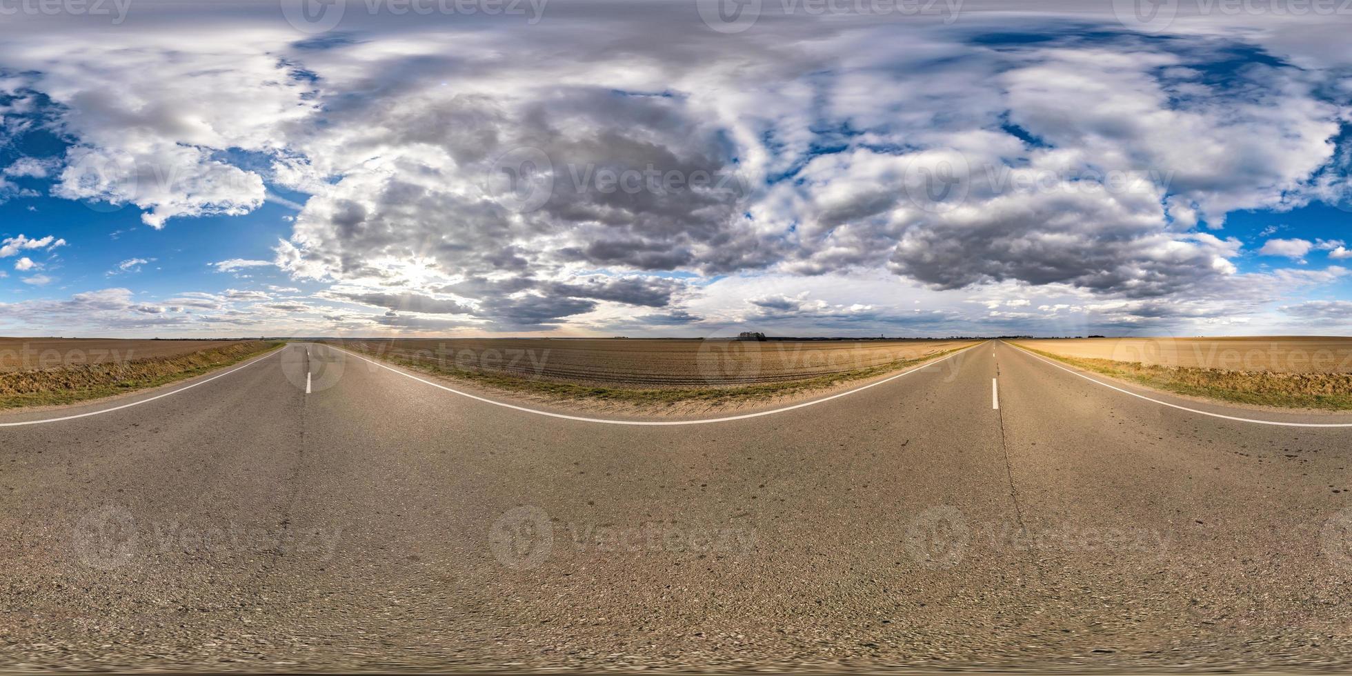 Panorama esférico completo sin costuras Vista angular de 360 grados en carretera asfaltada sin tráfico entre campos por la noche antes de la puesta del sol con cielo nublado. Panorama 360 en proyección equirrectangular, contenido vr ar foto