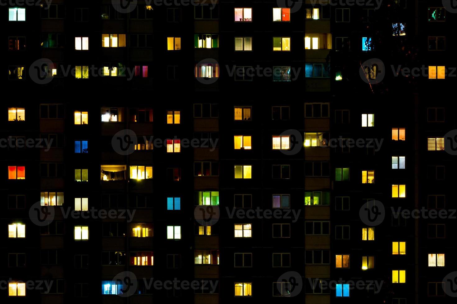 Flat night panorama of multicolor light in windows of multistory buildings. life in big city photo