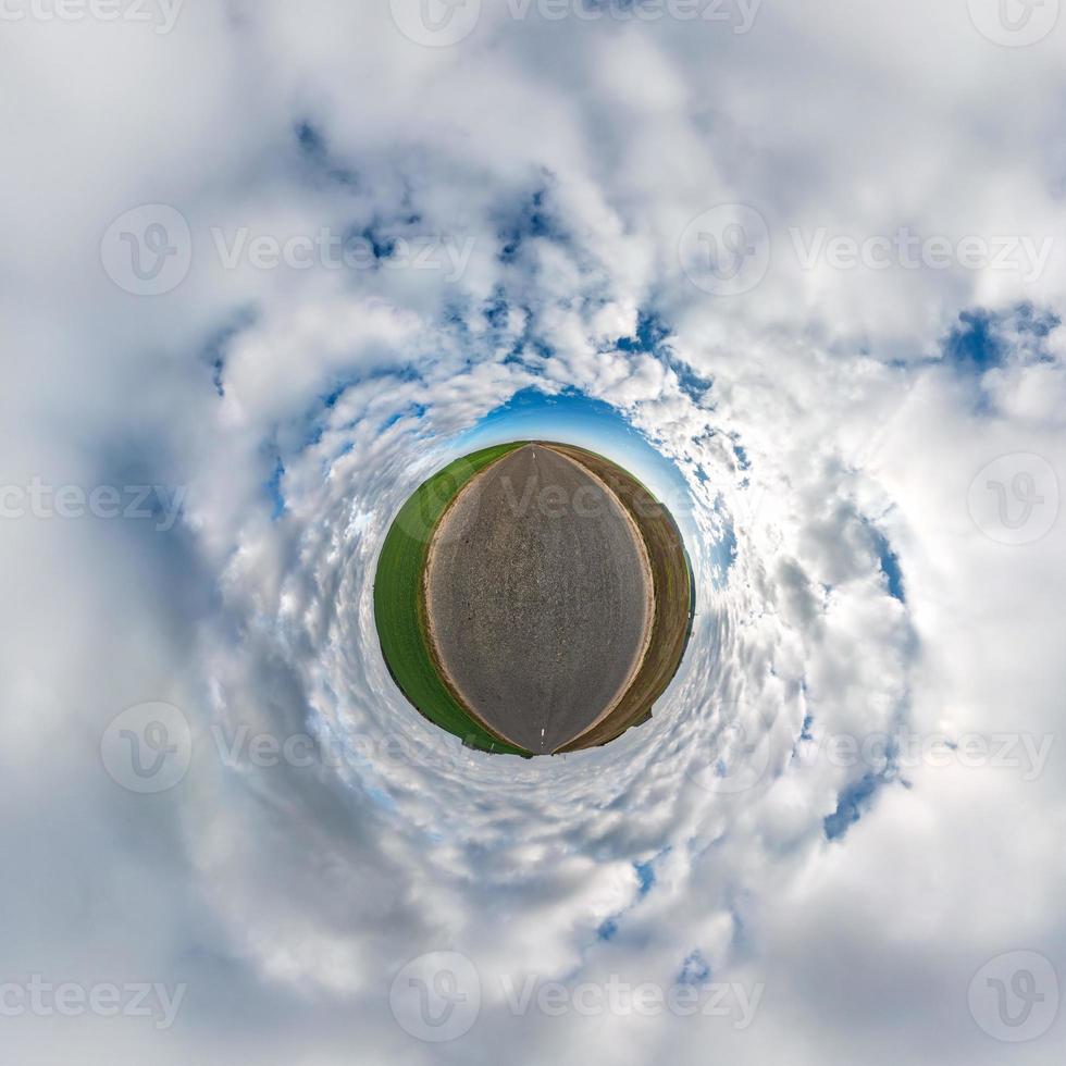 Little planet transformation of spherical panorama 360 degrees. Spherical abstract aerial view in field with awesome beautiful clouds. Curvature of space. photo