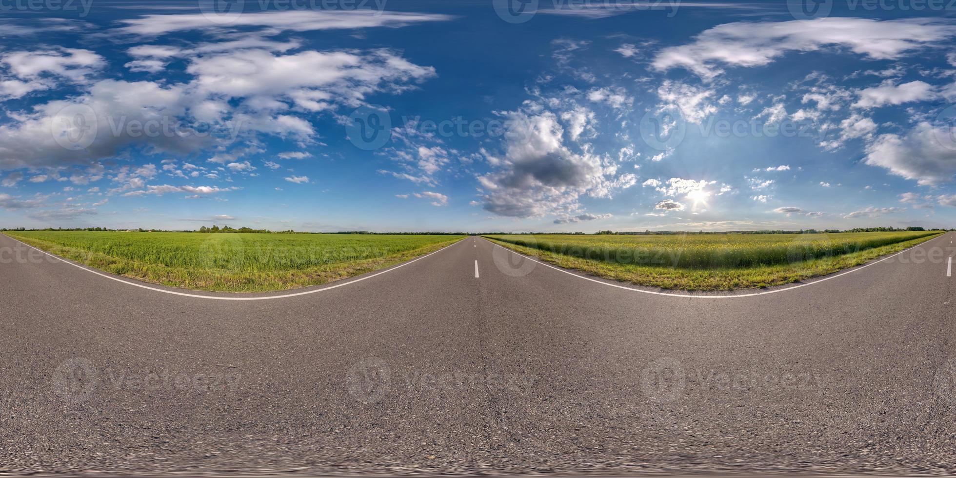 vista de ángulo de 360 grados de panorama hdri esférico completo sin tráfico en carretera asfaltada entre campos con cielo azul claro y hermosas nubes en proyección equirectangular, contenido vr ar foto