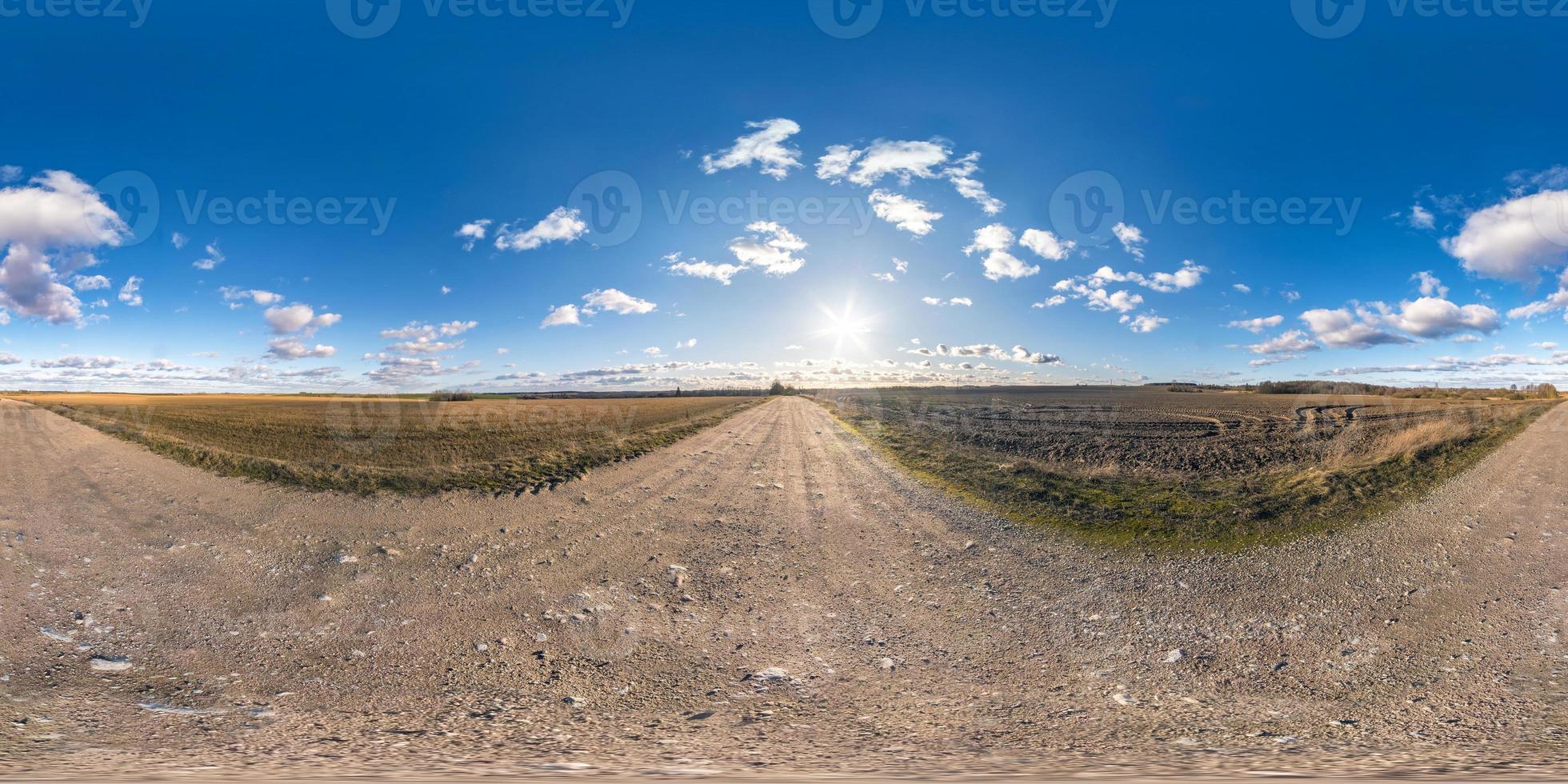 full seamless spherical hdri panorama 360 degrees angle view on gravel road among fields in spring day with awesome clouds in equirectangular projection, ready for VR AR virtual reality content photo