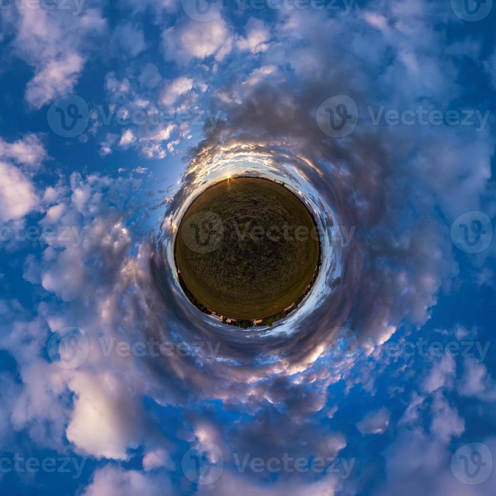 Little planet transformation of spherical panorama 360 degrees. Spherical abstract aerial view in field with awesome beautiful clouds. Curvature of space. photo