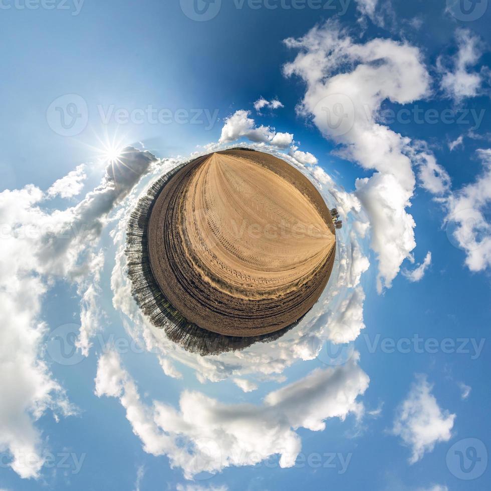 Little planet transformation of spherical panorama 360 degrees. Spherical abstract aerial view in field with awesome beautiful clouds. Curvature of space. photo