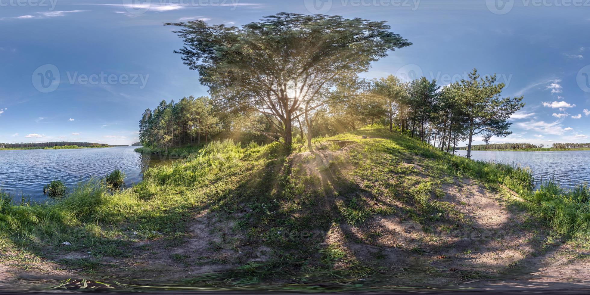 full seamless spherical hdri panorama 360 degrees angle view near huge tree on banks of wide river with rays of sun through branches  in equirectangular projection, ready VR AR virtual reality content photo