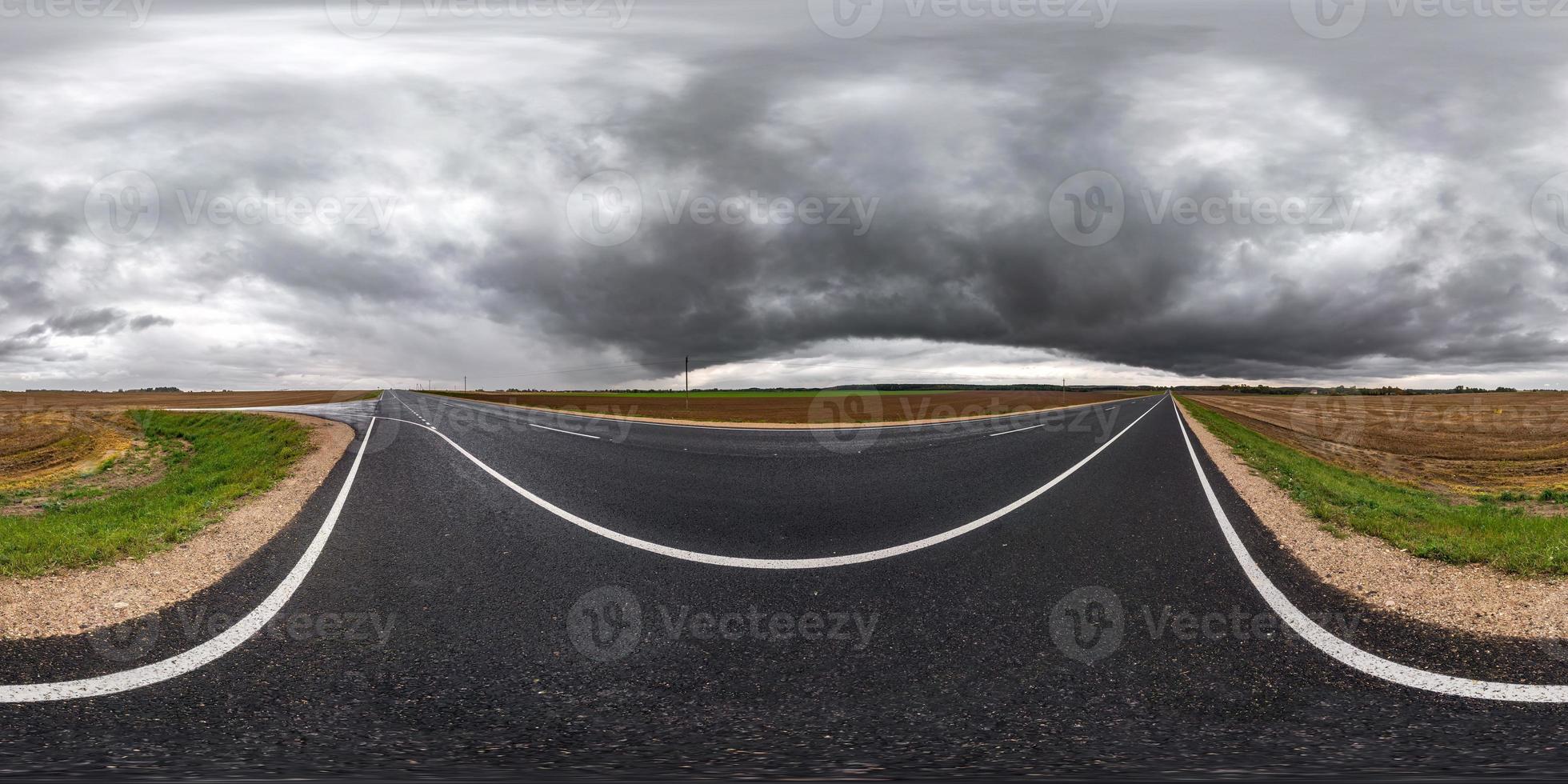 panorama hdri esférico completo sin costuras vista en ángulo de 360 grados en carretera asfaltada entre campos en el día de otoño con hermosas nubes antes de la tormenta en proyección equirectangular, listo para contenido vr ar foto