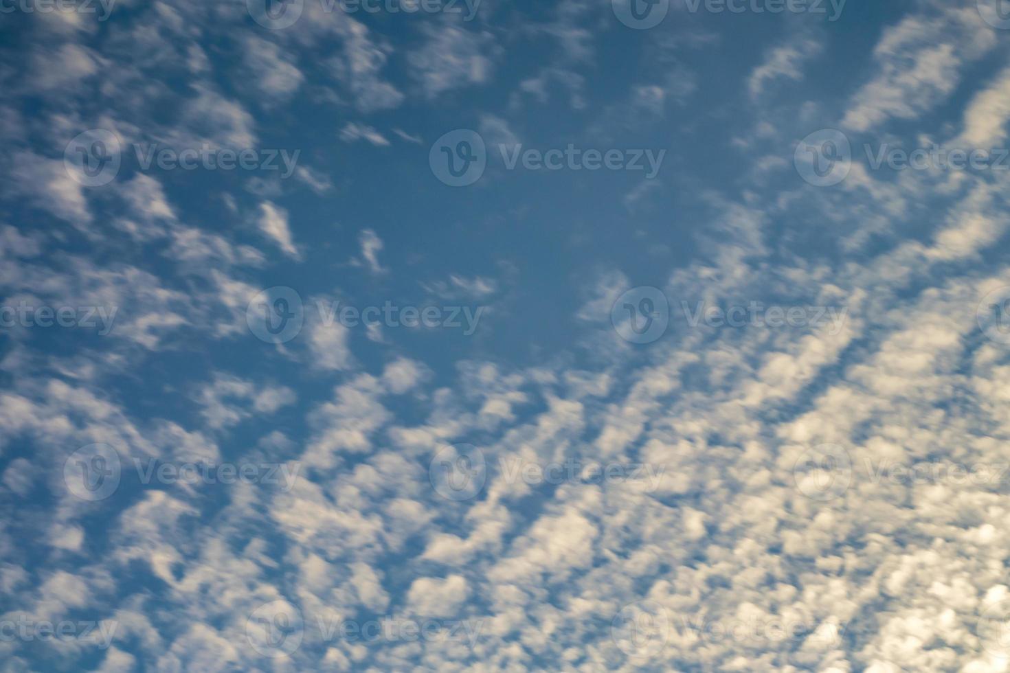 Blue sky background with tiny curly rolling clouds in the evening. Clearing day and Good windy weather photo