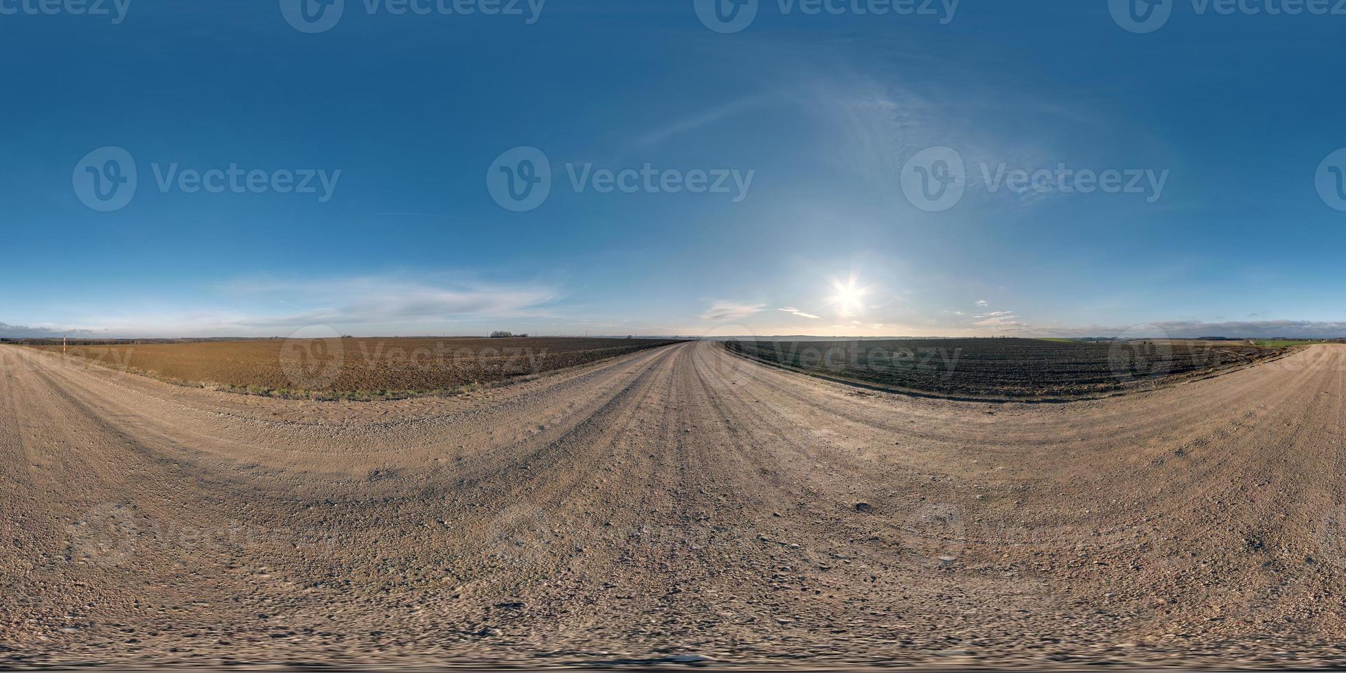 full seamless spherical hdri panorama 360 degrees angle view on gravel road among fields in autumn day with sun on clear sky in equirectangular projection, ready for VR AR virtual reality content photo