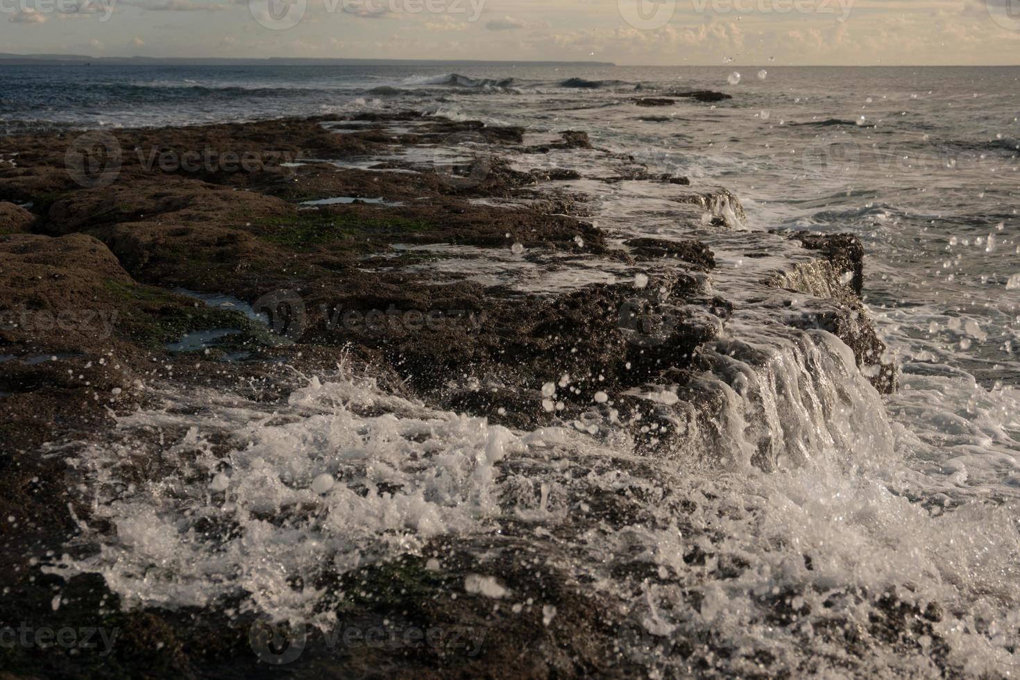 Splashing waves on the rock beach photo