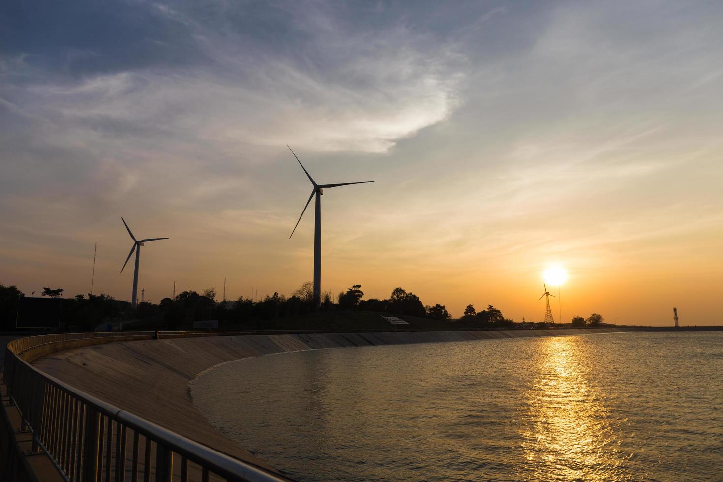 power generator wind turbines at sunset with reservoir photo
