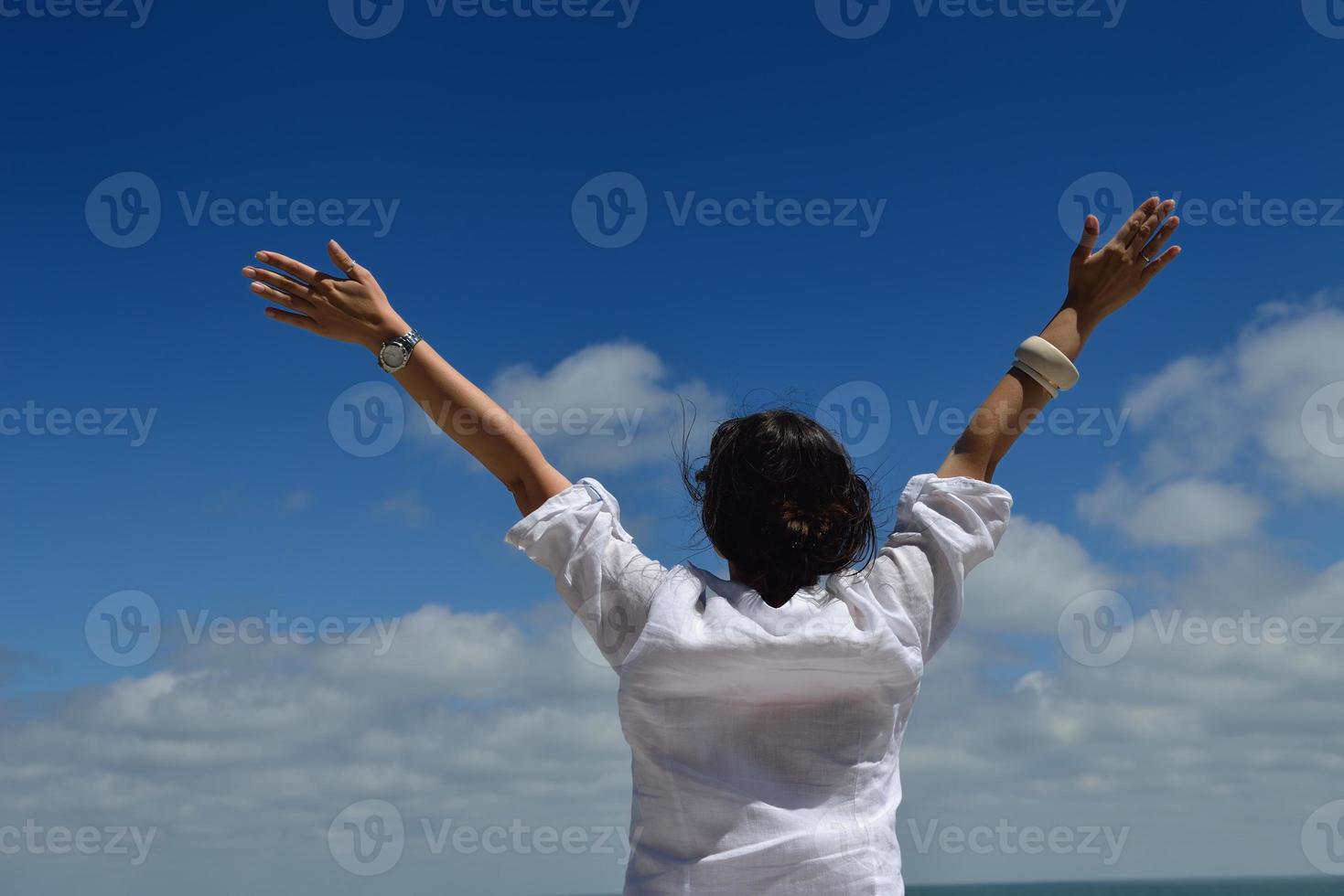 mujer joven con los brazos extendidos hacia el cielo foto