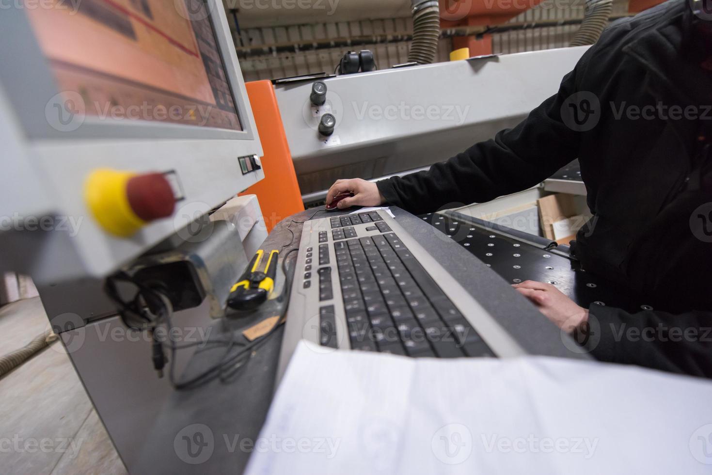 carpenters calculating and programming a cnc wood working machine photo