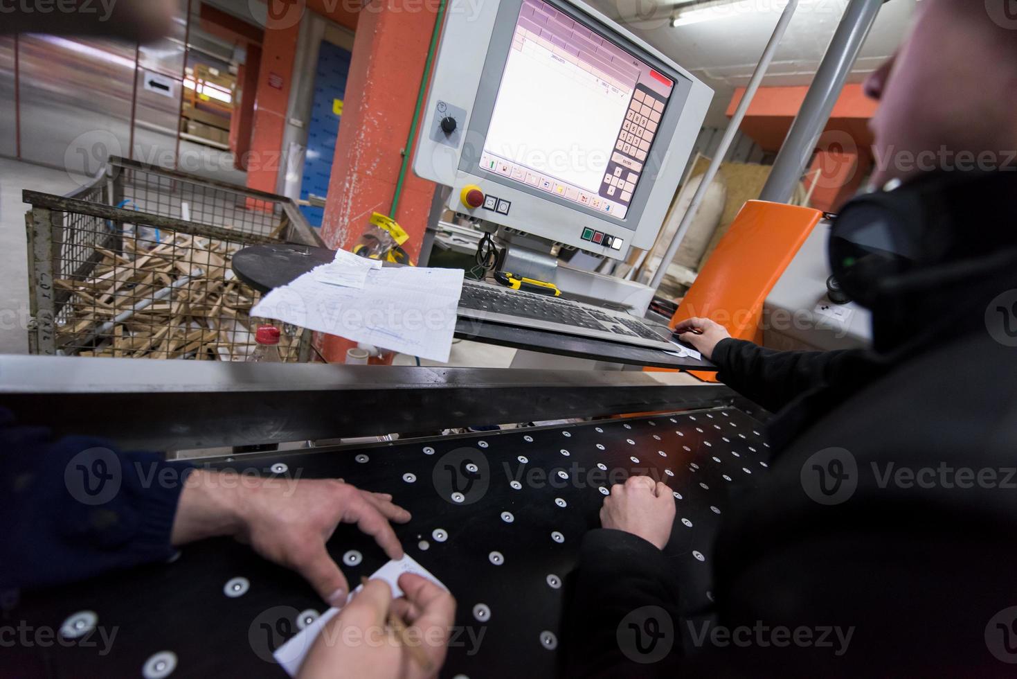 carpenters calculating and programming a cnc wood working machine photo