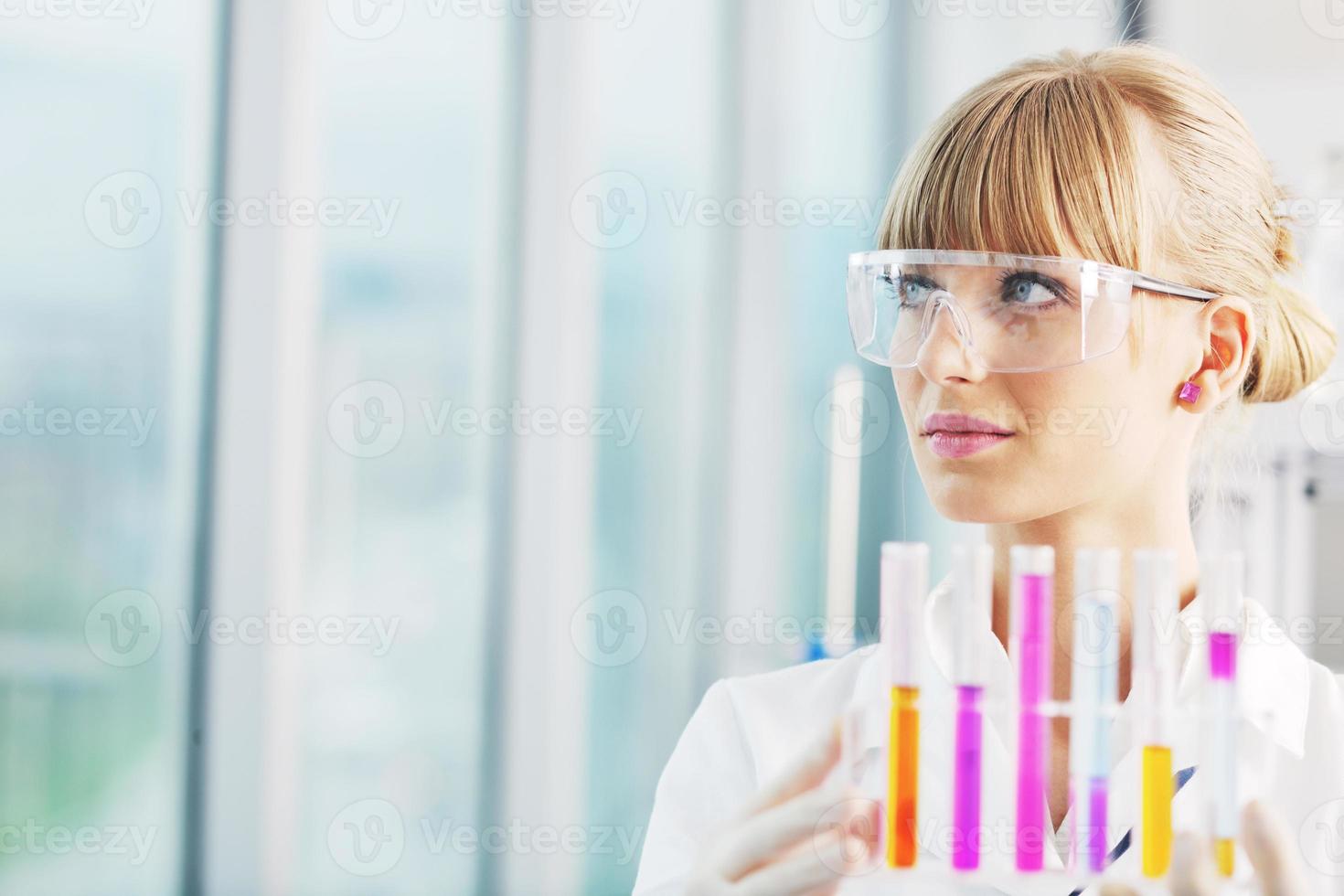 female researcher holding up a test tube in lab photo